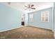 Bright bedroom with soft blue walls, ceiling fan, plantation shutters, and an ensuite bathroom at 3664 E Narrowleaf Dr, Gilbert, AZ 85298