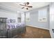 Stylish bedroom with light blue walls, ceiling fan, plantation shutters, and a comfortable bed with patterned bedding at 3664 E Narrowleaf Dr, Gilbert, AZ 85298