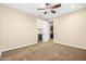 Carpeted bedroom with a ceiling fan, leading to a walk-in closet and en-suite bathroom at 3664 E Narrowleaf Dr, Gilbert, AZ 85298