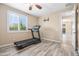 Bright exercise room featuring a treadmill, wood-look floors, plantation shutters and a ceiling fan at 3664 E Narrowleaf Dr, Gilbert, AZ 85298