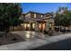 Inviting two-story home with a stone facade, well-lit garage, and manicured landscaping at twilight at 3664 E Narrowleaf Dr, Gilbert, AZ 85298