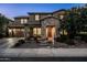Charming home with a stone-accented facade, neat landscaping, and an inviting entrance at twilight at 3664 E Narrowleaf Dr, Gilbert, AZ 85298