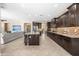 A kitchen is open to the living room with stainless appliances, a central island, and dark wood cabinetry at 3664 E Narrowleaf Dr, Gilbert, AZ 85298