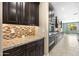 The kitchen features dark wood cabinets, granite countertops, stainless steel appliances, and a mosaic backsplash at 3664 E Narrowleaf Dr, Gilbert, AZ 85298