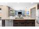 A kitchen island with stainless steel appliances, seating and a sink is open to the living room at 3664 E Narrowleaf Dr, Gilbert, AZ 85298
