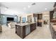 A kitchen island with stainless steel appliances, seating, sink, and dark wood cabinets and an open floor plan at 3664 E Narrowleaf Dr, Gilbert, AZ 85298
