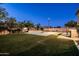 A backyard pool features an outdoor basketball court, trees, and well manicured artificial grass at 3664 E Narrowleaf Dr, Gilbert, AZ 85298