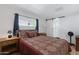 Bedroom featuring natural light, a sliding door to the bathroom, and warm furnishings at 4065 E University Dr # 332, Mesa, AZ 85205
