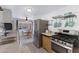 Kitchen with stainless appliances, tile backsplash, modern sink, and open dining area at 4065 E University Dr # 332, Mesa, AZ 85205