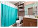 Traditional bathroom featuring decorative shelves and a shower with a blue and white curtain at 4702 N 124Th Ave, Avondale, AZ 85392
