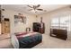 Comfortable bedroom with a ceiling fan, window for natural light, and a dog kennel at 4702 N 124Th Ave, Avondale, AZ 85392
