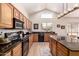 Well-equipped kitchen with black appliances, granite countertops, and wooden cabinetry at 4702 N 124Th Ave, Avondale, AZ 85392