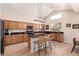 Bright kitchen with wood cabinets, granite counters, an island with seating and modern lighting at 4702 N 124Th Ave, Avondale, AZ 85392
