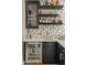 Stylish wet bar features custom cabinets, open shelving for bottles, beverage fridge, and attractive backsplash at 5420 E Duane Ln, Cave Creek, AZ 85331