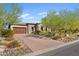 Attractive house features a brick driveway, a two-car garage, and lush desert landscaping in the front yard at 5420 E Duane Ln, Cave Creek, AZ 85331
