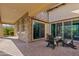 Covered outdoor patio with stone accents, brick flooring, and comfortable lounge seating area, perfect for relaxation and entertaining at 5420 E Duane Ln, Cave Creek, AZ 85331