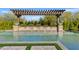 Stunning backyard pool features a beautiful pergola with planters and tranquil waterfall features for relaxation at 5420 E Duane Ln, Cave Creek, AZ 85331