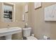 Elegant powder room featuring a pedestal sink, toilet, mirror, and tastefully decorated walls at 5420 E Duane Ln, Cave Creek, AZ 85331