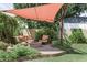 A cozy backyard space with a shaded seating area, a fire pit, and lush greenery at 5808 N 18Th Pl, Phoenix, AZ 85016