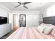 Bright bedroom features a ceiling fan, sliding closet doors, and a comfortable bed with a tufted headboard at 5808 N 18Th Pl, Phoenix, AZ 85016