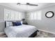 Bedroom featuring a bed with gray and blue accents, white shutters, and a modern ceiling fan at 5808 N 18Th Pl, Phoenix, AZ 85016