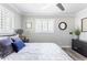Bedroom with wood look floors, white shutters, ceiling fan, and modern grey walls at 5808 N 18Th Pl, Phoenix, AZ 85016