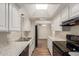 Galley kitchen features white cabinets, granite countertops, and stainless steel sink and appliances at 6126 N 31St Dr, Phoenix, AZ 85017