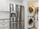 Close up of stainless steel refrigerator next to a laundry closet in the kitchen at 614 N Pioneer Cir, Mesa, AZ 85203