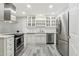 Well-lit kitchen featuring stainless steel appliances, white cabinets, and modern backsplash at 614 N Pioneer Cir, Mesa, AZ 85203