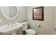 Elegant bathroom features a pedestal sink, decorative mirror, and a toilet at 6162 E Redmont Dr, Mesa, AZ 85215