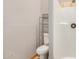 Bathroom featuring a toilet, chrome shelving unit, and tiled shower at 7506 W Sells Dr, Phoenix, AZ 85033