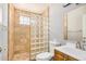 Bathroom featuring tile shower with glass block wall, modern toilet and sink at 7506 W Sells Dr, Phoenix, AZ 85033