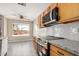 Modern kitchen featuring stainless steel appliances, tile backsplash, and eat-in area at 7506 W Sells Dr, Phoenix, AZ 85033