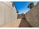 View of the side yard featuring a brick wall and a wooden fence under a clear blue sky at 7506 W Sells Dr, Phoenix, AZ 85033