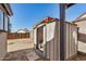 Exterior view of a metal storage shed with sliding doors in the backyard under a clear sky at 7506 W Sells Dr, Phoenix, AZ 85033