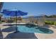 Beautiful pool with rock waterfall, outdoor grill, seating and sun umbrellas provides a luxurious outdoor space at 797 E Cedar Dr, Chandler, AZ 85249
