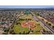 An aerial view of baseball fields, a community park with a pool, lake and playgrounds with surrounding neighborhood at 8301 E Indianola Ave, Scottsdale, AZ 85251