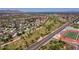 Expansive aerial view showcases community with golf course, football field, and mountain views in the distance at 8301 E Indianola Ave, Scottsdale, AZ 85251