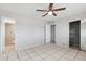 Spacious bedroom with tile flooring, a ceiling fan, and access to a closet, great for storage and comfort at 8301 E Indianola Ave, Scottsdale, AZ 85251