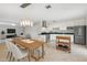 Open concept kitchen with stainless steel appliances, white cabinetry, dining table, and recessed lighting at 8301 E Indianola Ave, Scottsdale, AZ 85251