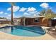 Relax by this sparkling pool with a charming red brick home and shaded patio in the background at 8301 E Indianola Ave, Scottsdale, AZ 85251