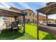 Backyard with artificial turf, a patio dining set, pool with waterfall, and shaded pergola at 84 E Joseph Way, Gilbert, AZ 85295