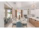 Dining area with kitchen view, white cabinetry, modern lighting, and sliding door access to the outdoor patio at 84 E Joseph Way, Gilbert, AZ 85295