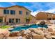 Backyard with a custom pool featuring a rock waterfall and slide, plus a small island with palm trees at 84 E Joseph Way, Gilbert, AZ 85295