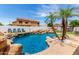 Lush backyard with resort-style pool, mature palm trees, rock features, and outdoor seating area at 84 E Joseph Way, Gilbert, AZ 85295