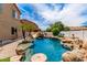 Resort-style pool with rock waterfall, slide, and lush landscaping create a stunning backyard retreat at 84 E Joseph Way, Gilbert, AZ 85295