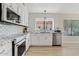 Bright kitchen with stainless steel appliances, mosaic backsplash, and sleek countertops at 912 W Sunward Dr, Gilbert, AZ 85233
