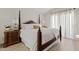 Serene bedroom with four-poster bed, wood-look flooring, and ample natural light, creating a relaxing retreat at 912 W Sunward Dr, Gilbert, AZ 85233