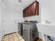 Well-lit laundry room featuring modern washer and dryer, storage cabinets, and utility sink at 9637 E Gold Dust Ave, Scottsdale, AZ 85258