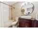 Bathroom with a stylish vanity, vessel sink, round mirror, and tiled shower at 9801 W Rockwood Dr, Peoria, AZ 85382